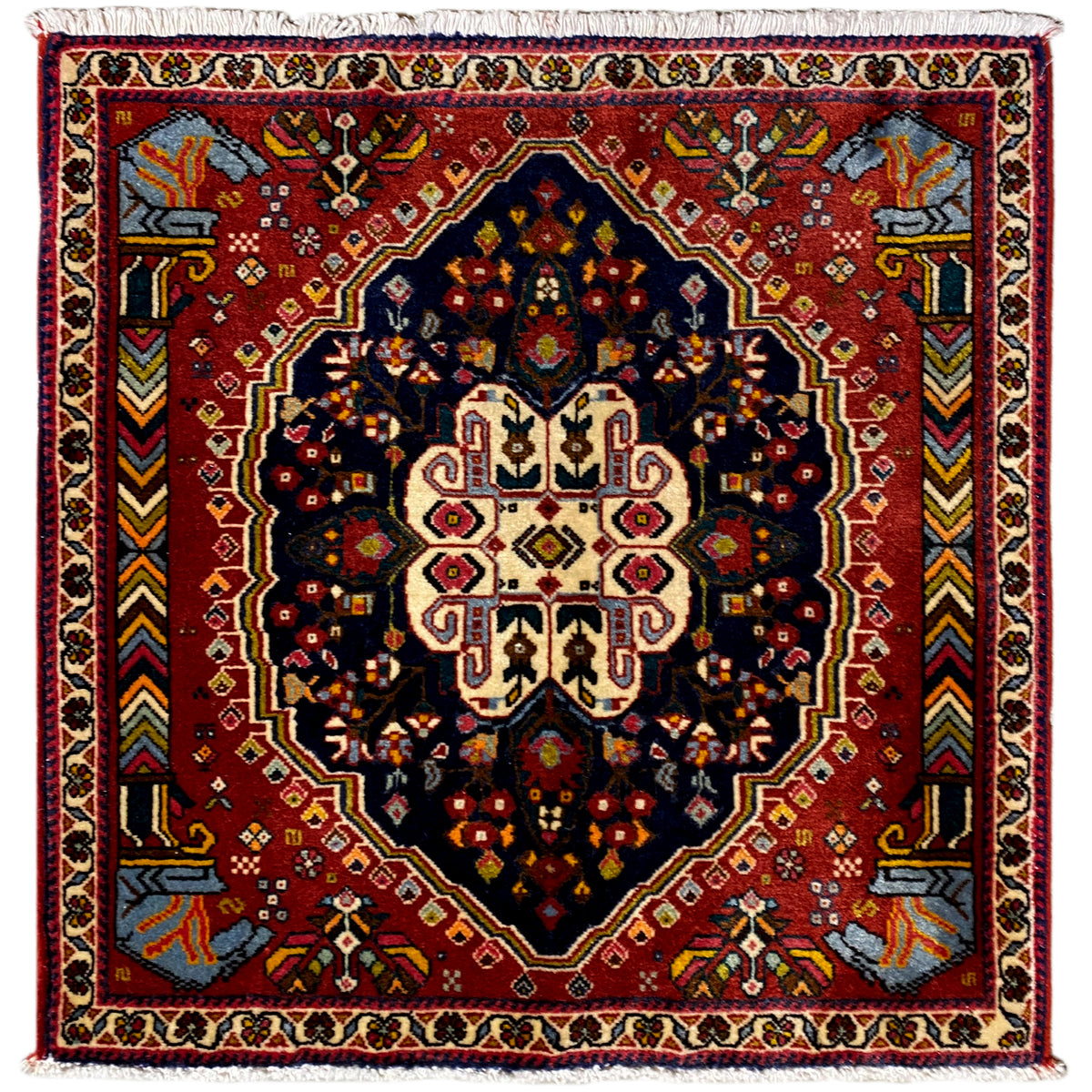 Poshti rug with a red background, dark blue octagonal pattern, and white border trim