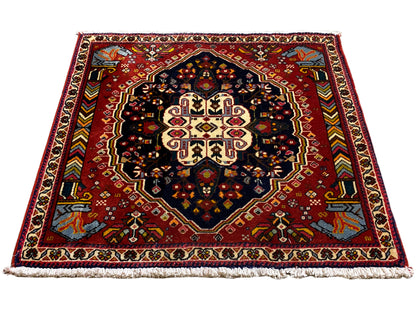 Poshti rug with a red ground and symmetrical medallion, blue-black contrasting field