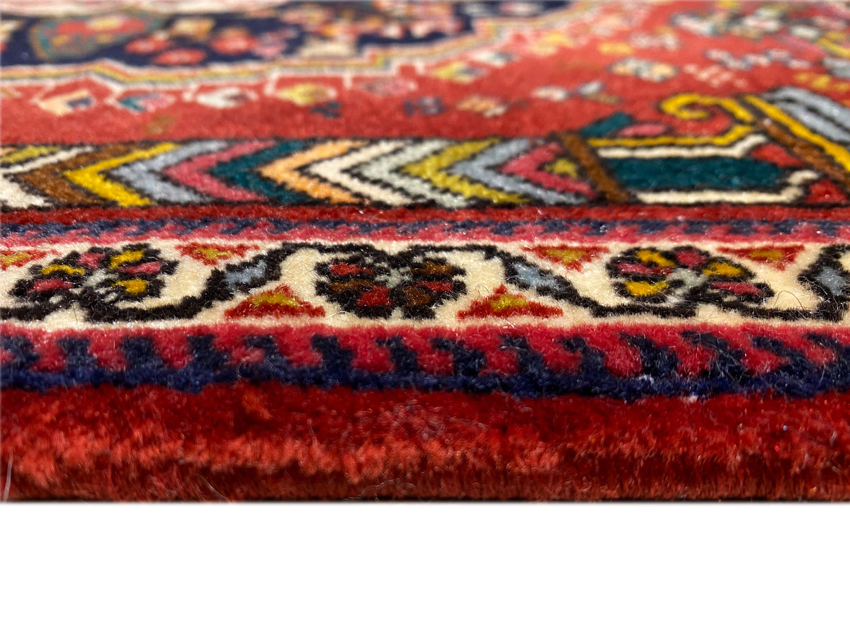 Poshti rug edge detail with red and blue fringes and woven patterns