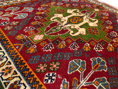 Close-up of the Oriental rug: red field with floral motifs and green accents