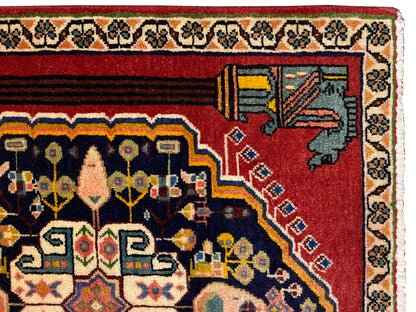 Close-up of a Poshti rug: red border with decorative corner motifs and ornamental bands