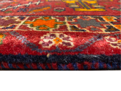 Close-up of the carpet edge with red pile and multicolored trim