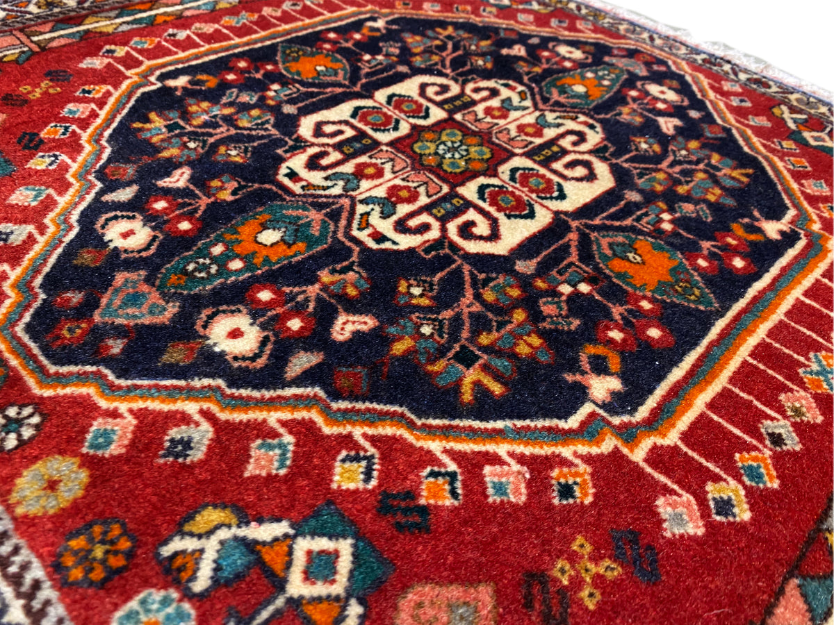 Rug surface: central ornament on a dark blue background, colored border, fringed edge