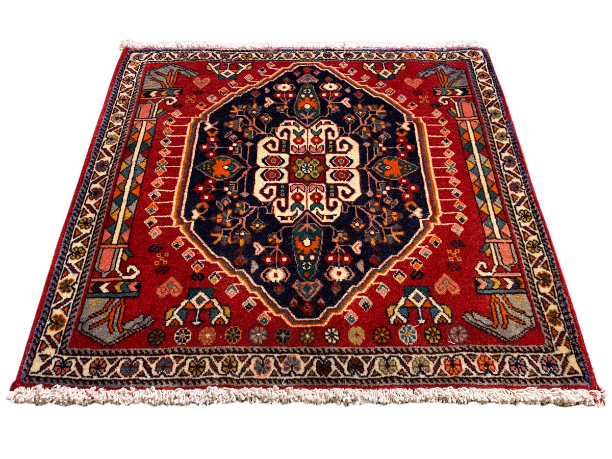 Rug with a red background, dark blue medallion, symmetrical ornament, rectangular