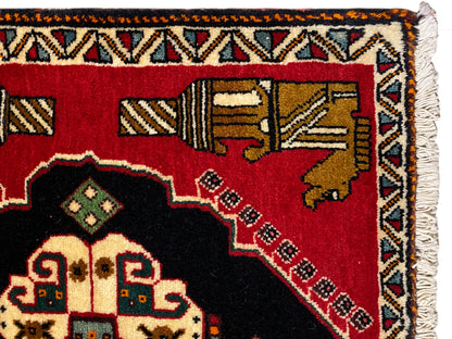 Poshti rug 63x55 cm: edge detail with fringe and multicolored ornamental stripe on a red background