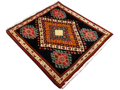 Poshti rug spread out in a diamond view: black base, orange patterns, and red/green fields