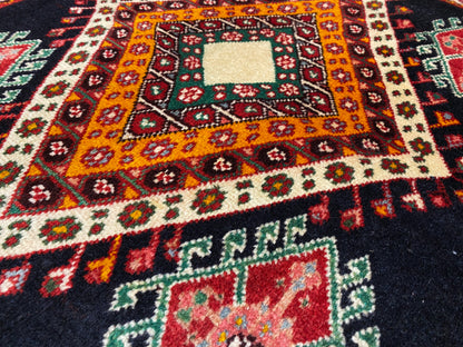 Poshti rug detail view with an orange-yellow central diamond, small ornamental elements, and a white center