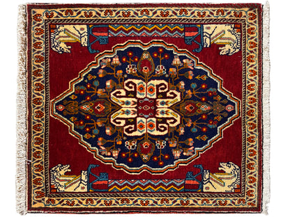 Rectangular rug with a red background, dark blue ornaments, and beige decorative borders