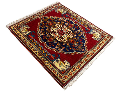 Rug in a diamond pattern with a red background, dark blue center, and fringe