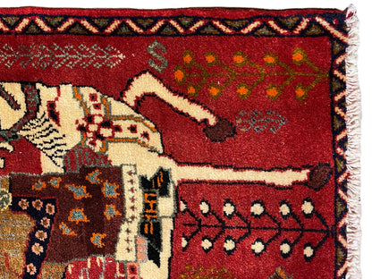 Close-up of a Poshti rug: red pile with a white horse motif, bordered by decorative edges
