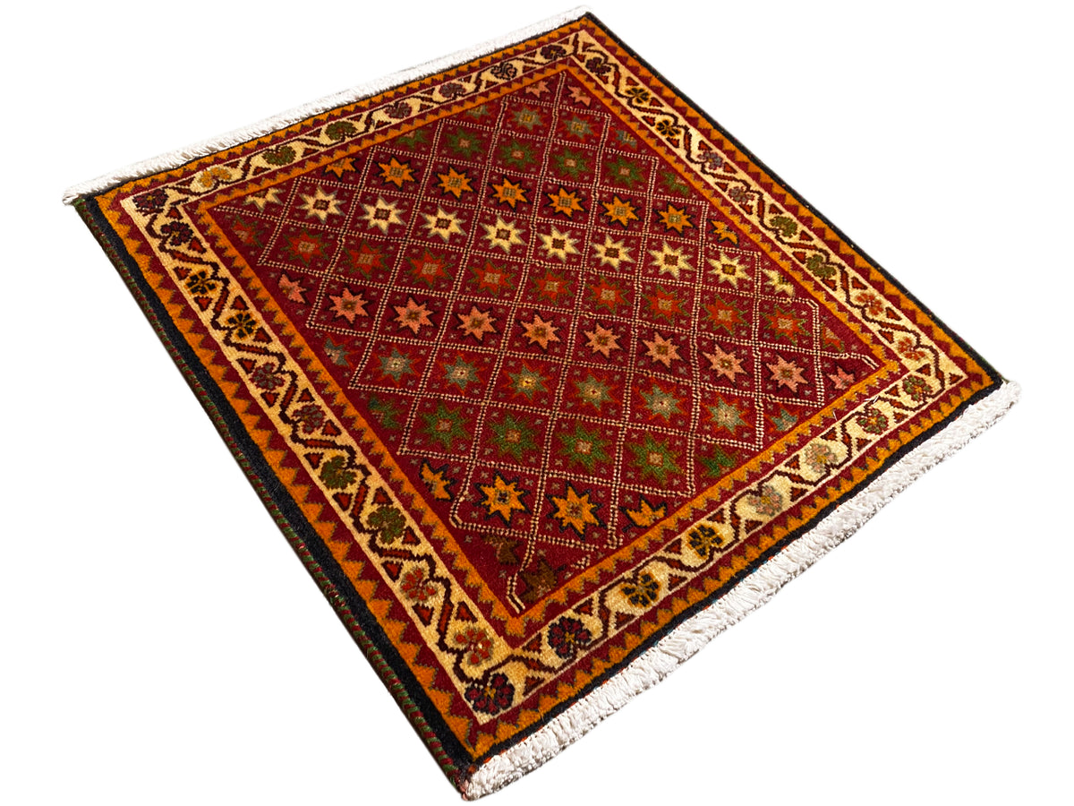 Poshti rug, rectangular, diagonal view: red central field with star patterns and border.