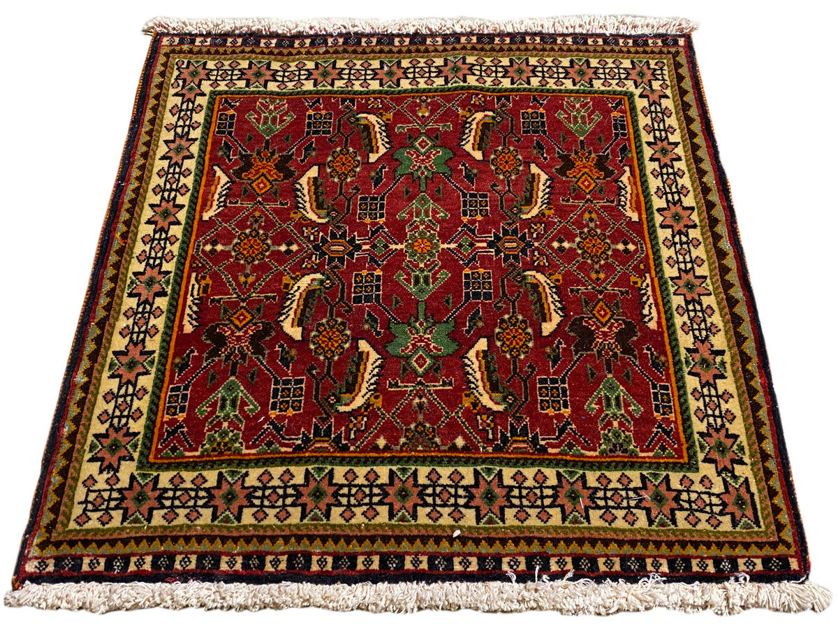 Poshti rug 63x61 cm, angled view: red ornamental pattern in green and beige.