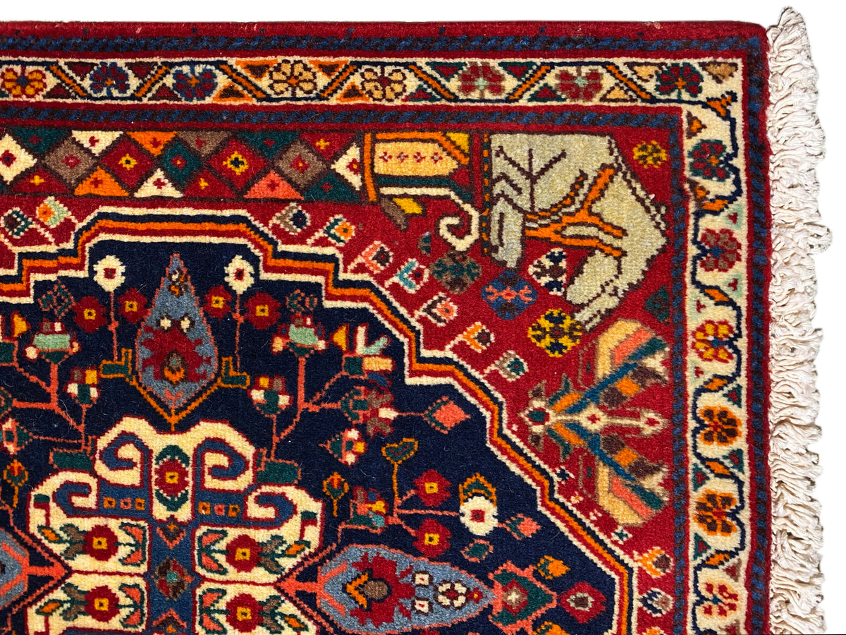 Close-up of the carpet edge with a blue ornamental field, red details, and fringe