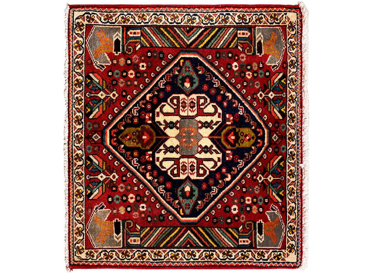 Oriental rug with a red background, dark blue medallion, and geometric ornaments