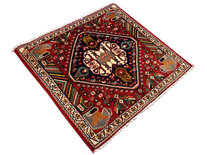 Square oriental rug with a red background and a blue-bordered central field