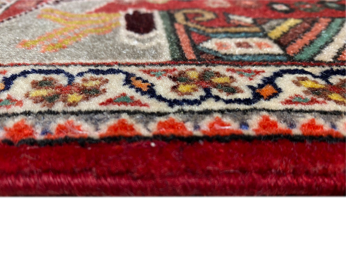 Close-up: carpet edge with fringe, red trim, and a dense ornamental pattern
