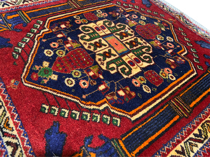 Poshti rug 66x62 cm Detail: red central pattern, blue field, and colorful decorative lines.