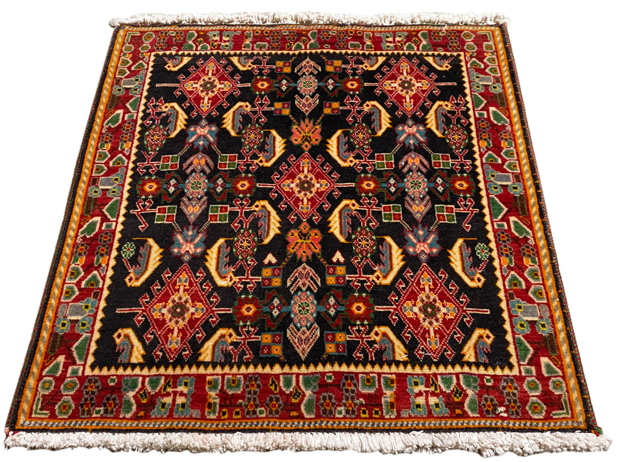 Rug with a symmetrical Poshti pattern, black background, shades of red, gold, and green