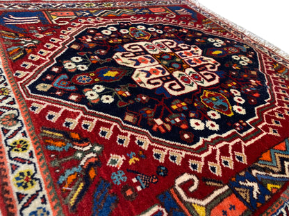 Close-up of a carpet with a multicolored geometric pattern on a dark blue background