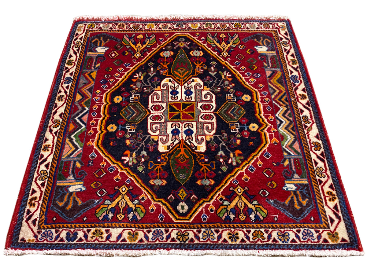 Poshti rug (67×67 cm) in angled view: border, red center, dark blue