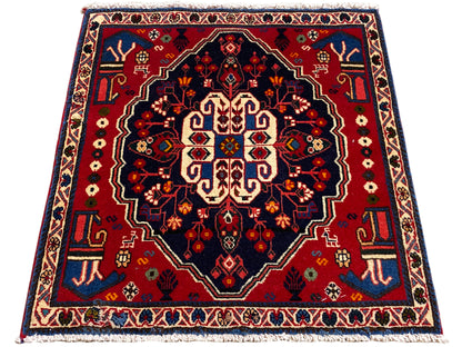 Square rug with a red border and dark field, stylized central ornament