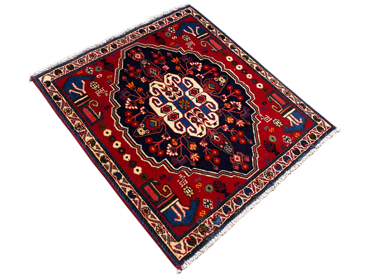 Carpet in a diamond layout: red patterned field with a blue border and ornaments