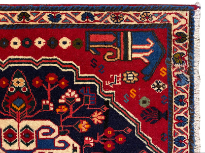 Carpet corner with a red background, colorful symbols, and a blue decorative border