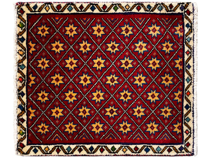 Square rug with a red motif and a multicolored geometric tiled star pattern