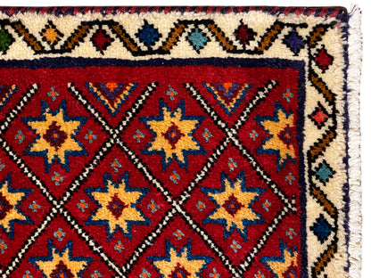 Rug detail at the edge: red star pattern with a white, patterned border frame