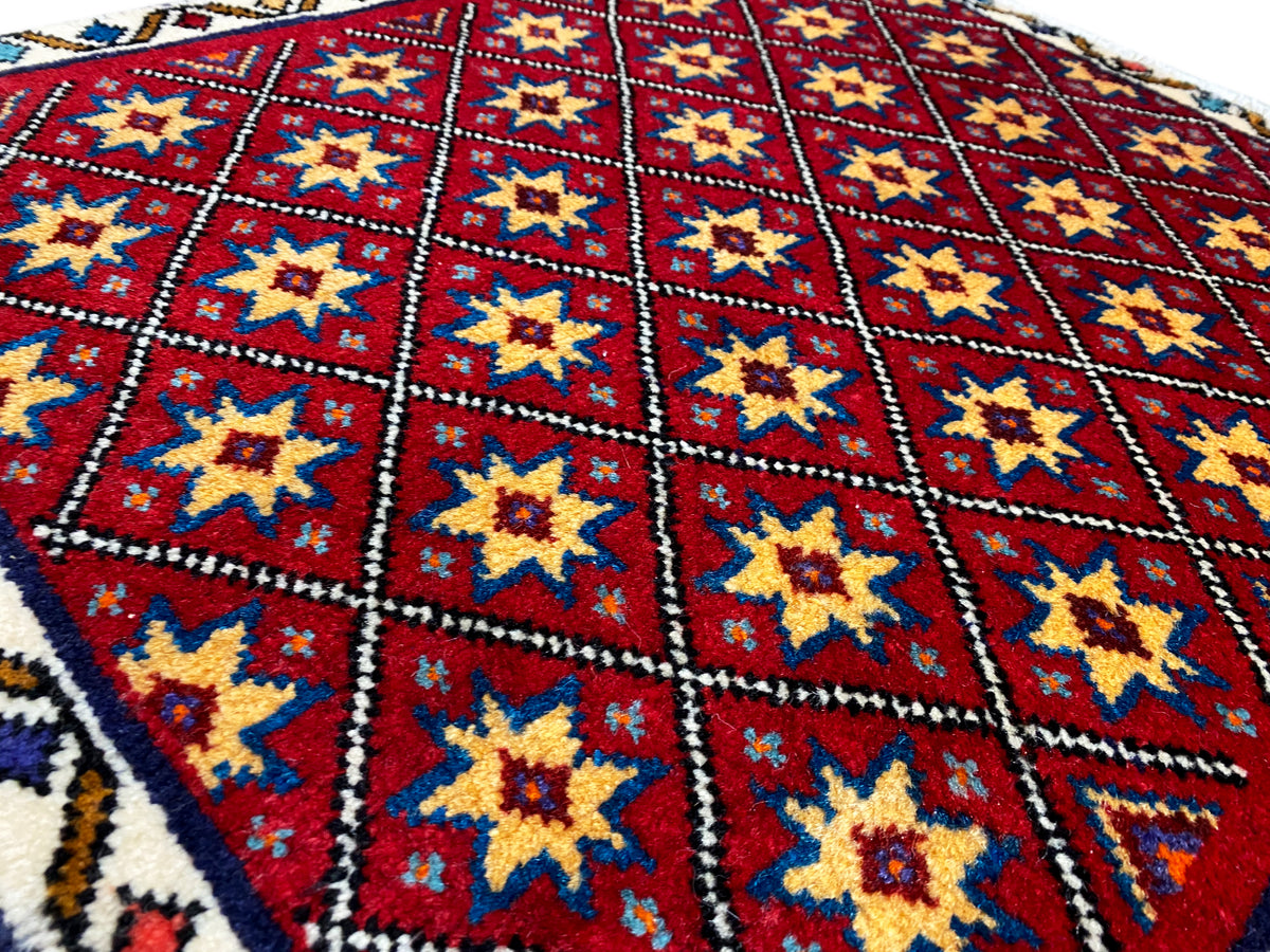 Close-up of the carpet: red diamond pattern with yellow and blue stars