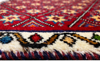 Rug detail: red-and-blue pattern with fringe along the bottom edge